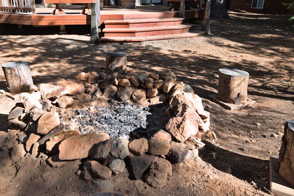 Dorrington Vacation Rental Cabins - A fire pit next to a wooden deck.