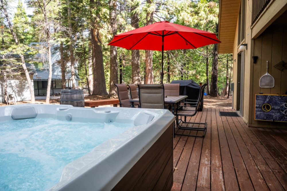Dorrington Vacation Rental Cabins - Evergreen Cottage Hot Tub with a red umbrella.