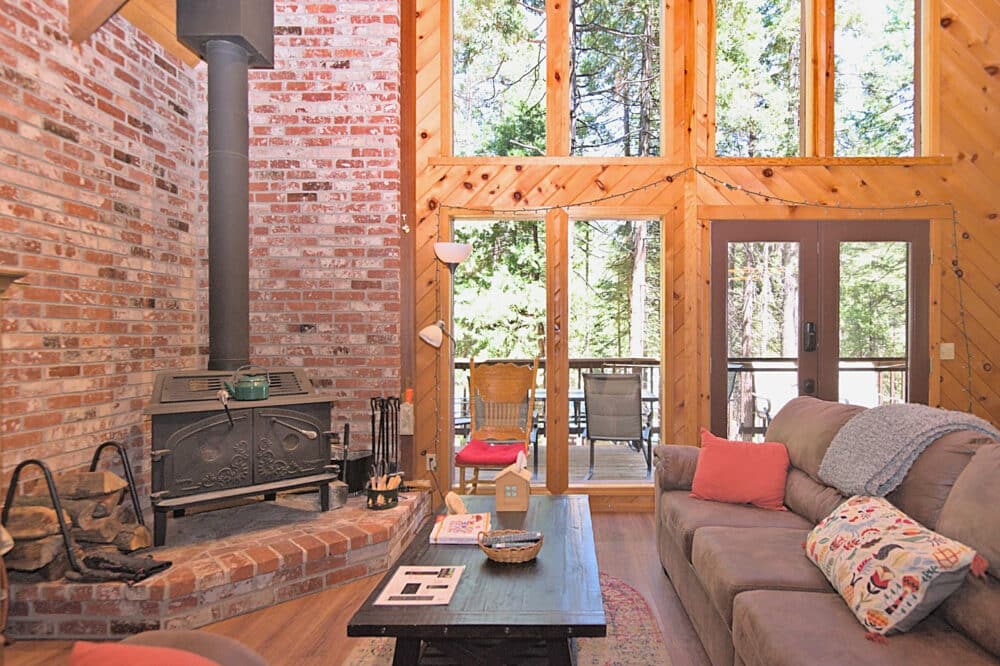 Dorrington Vacation Rental Cabins - Family-friendly living room with a fireplace and large windows.