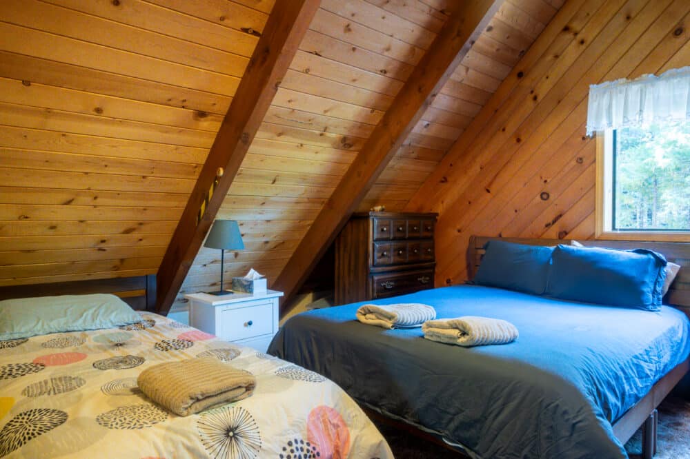 Dorrington Vacation Rental Cabins - A bedroom with a bed and a bedside table.