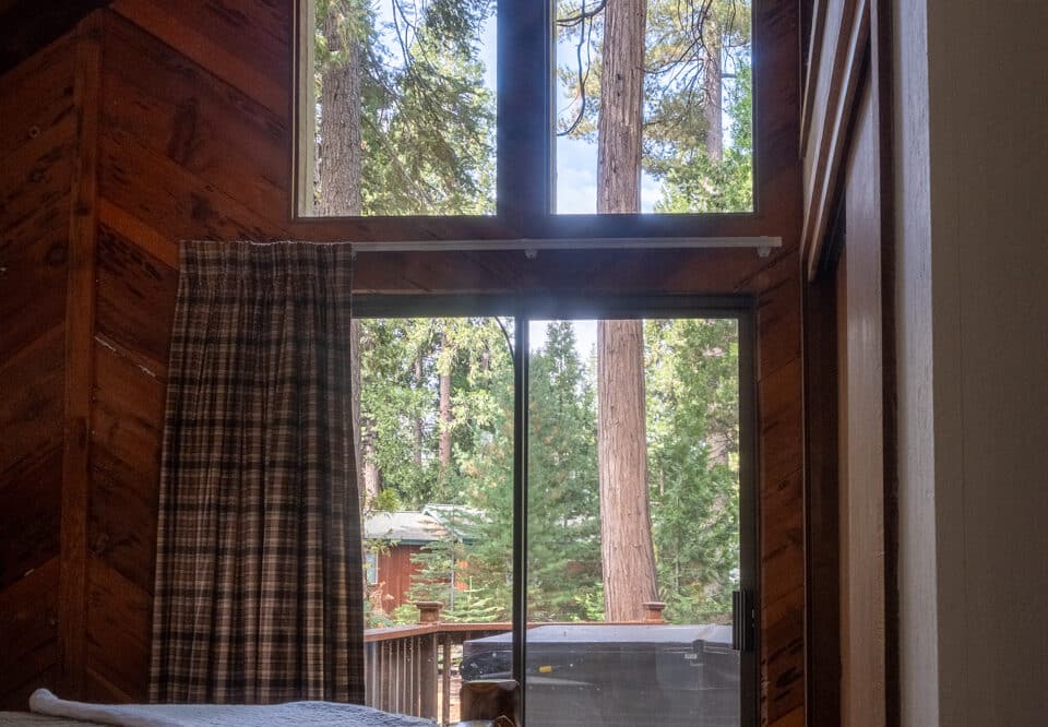 Dorrington Vacation Rental Cabins - A bedroom with a bed and a sliding glass door.