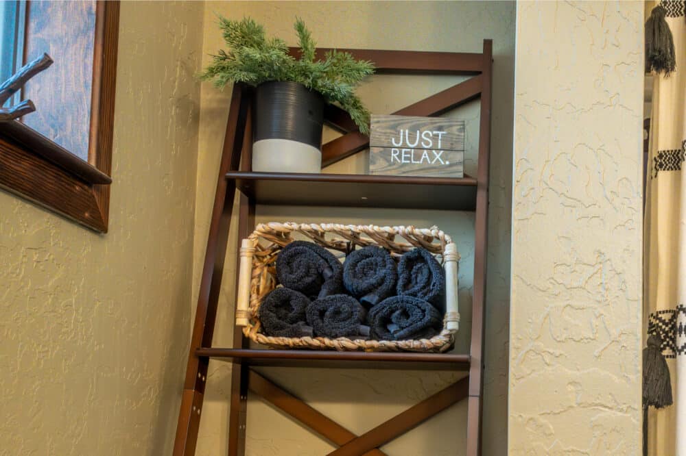Dorrington Vacation Rental Cabins - A ladder shelf with baskets and towels on it.
