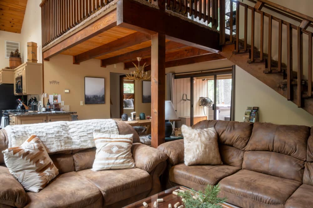 Dorrington Vacation Rental Cabins - A living room with couches and a staircase.