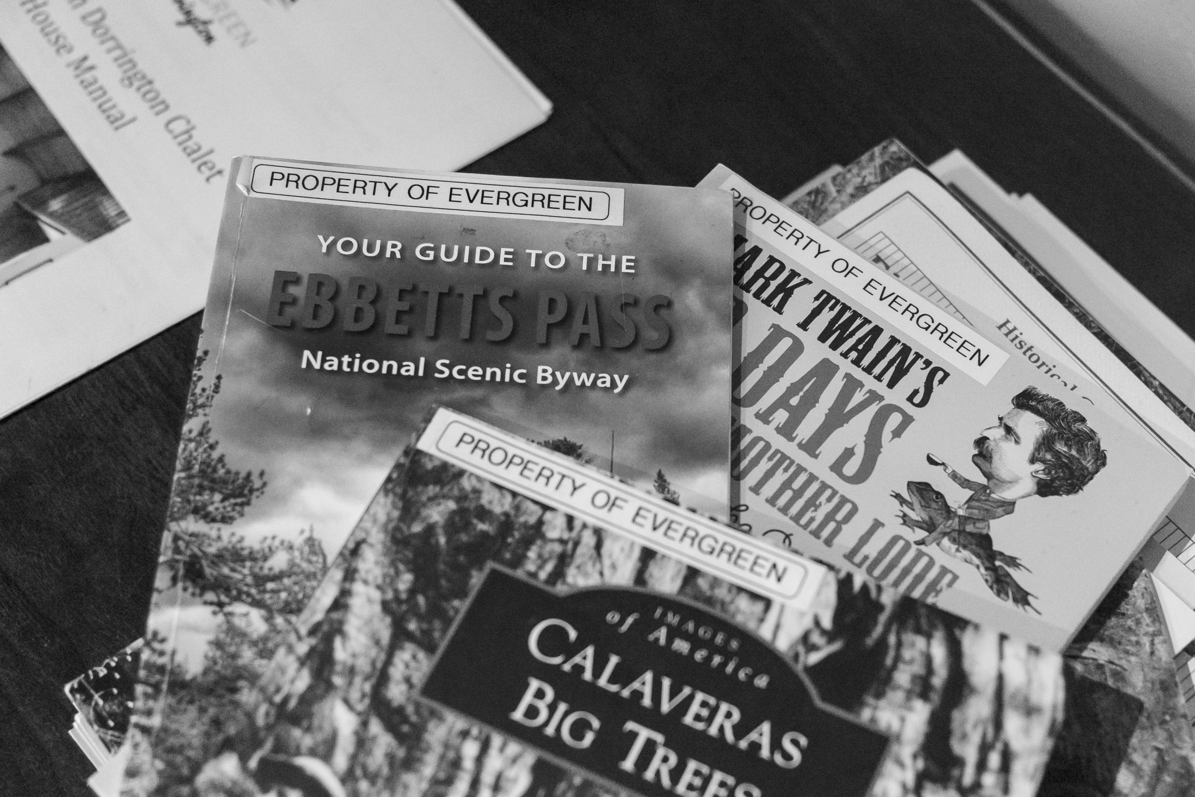 vacation rental cabin Black and white photo of brochures, including “Ebbetts Pass National Scenic Byway,” “Calaveras Big Trees,” and “Mark Twain’s Days Another Look,” marked “Property of Evergreen.”. near Arnold California
